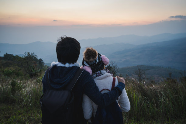 日落时分，一对恋人在山上拥抱。图片下载
