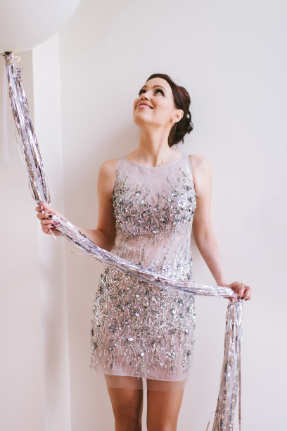 肖像迷人的女模特穿着银色闪闪发光的衣服拿着气球在手里图片下载
