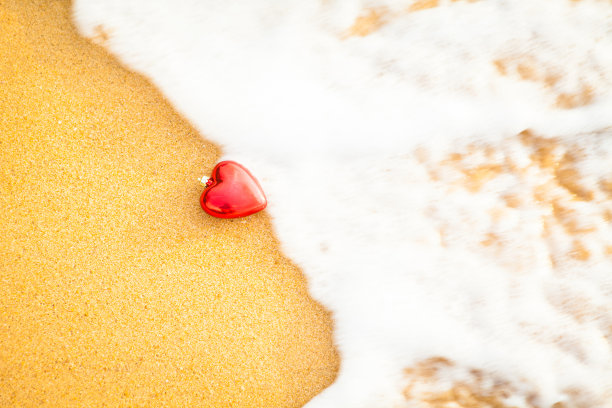 心在沙滩上，用柔软的波浪温暖的光。抽象背景喜欢夏季复古色调。图片下载