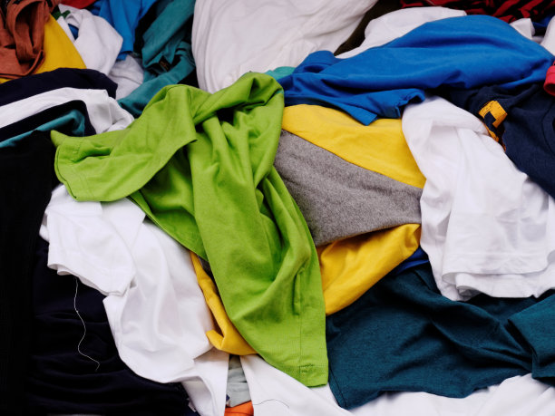 街道市场上的服装商店里，五颜六色的绿、蓝、黄、白，成堆的衣服在出售图片下载