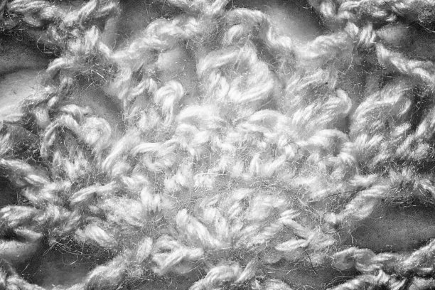 白色手工花边桌布纹理在白色的背景。特写视图。从中心偏黑图片下载