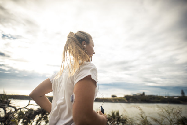 戴着葡萄糖传感器在户外跑步的糖尿病妇女素材图片