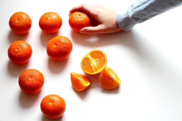 收集新鲜橙子。女人手中多汁的橙子孤立在白色的背景上。前视图。食物背景图片设计图片下载