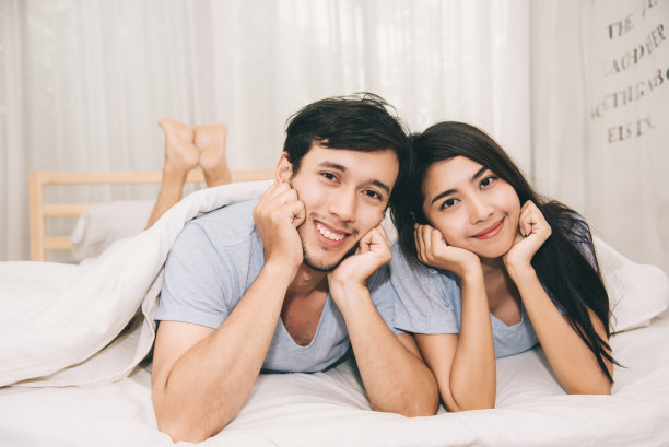 甜蜜的年轻夫妇在卧室的床上,幸福的时刻图片下载