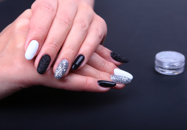 黑、白指甲艺术美甲。假日风格亮闪闪的美甲。美丽的手。时尚的指甲，指甲油图片下载