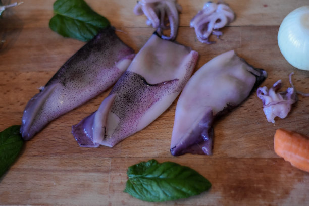 生鱿鱼，罗勒，迷迭香，土豆和蔬菜在木制背景/俯视图/特写图片下载