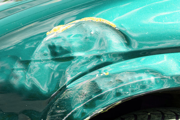 在交通事故中或停车场中有油漆损坏的绿色刮花车图片下载