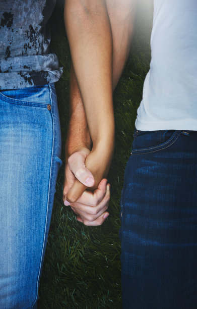 两个面目全非的男人手牵着手躺在草地上图片下载