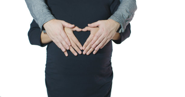 情侣相拥，双手在孕妇腹部组成心形 - 情人节概念图片下载