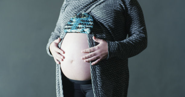 怀孕40周的母亲手编织婴儿豆帽以上的大婴儿隆起图片下载