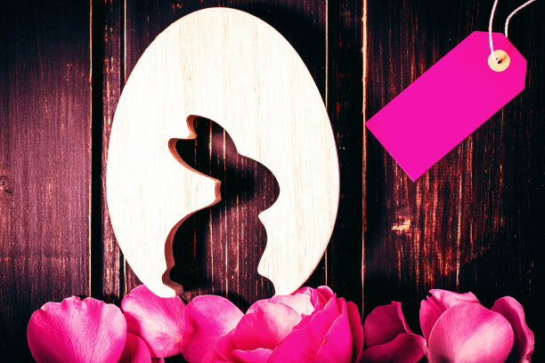 复活节兔子和鸡蛋与玫瑰花叶子特写和销售标签或标签在木制背景与复制空间。复活节销售，问候和庆祝卡的概念。图片下载