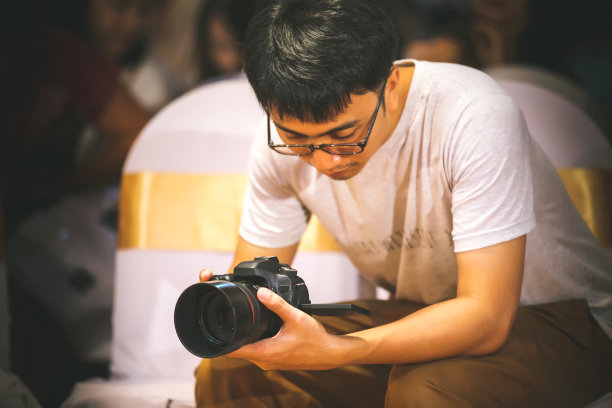 摄影师兼视频制作者手持单反相机拍摄画面素材图片