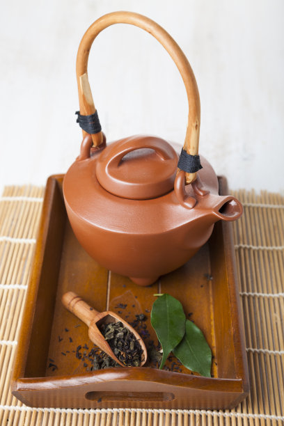 木制托盘上的陶瓷茶壶。图片下载