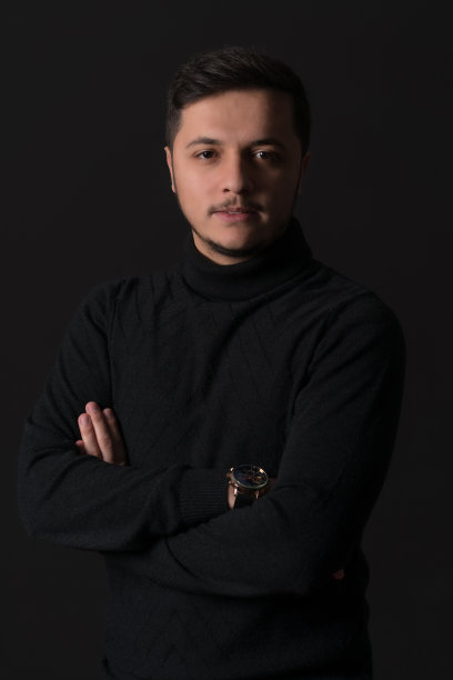 英俊的年轻人在黑色的背景图片下载