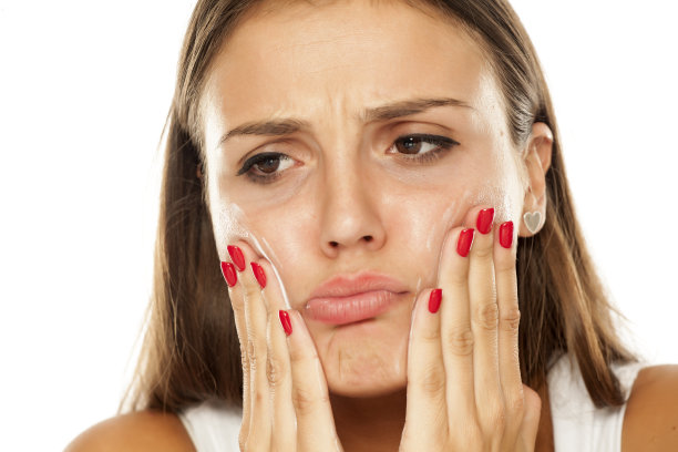 年轻紧张的女人在脸上擦面霜素材图片