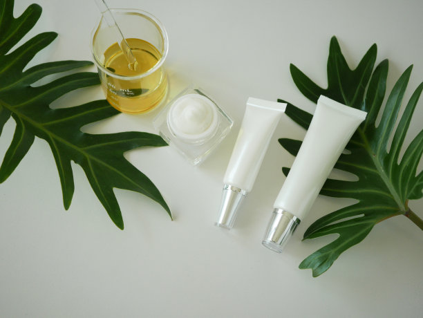 化妆品包装容器。天然有机美容产品概念模拟与绿叶，草药。空白瓶标签皮肤护理。孤立的白色背景。前视图。图片下载