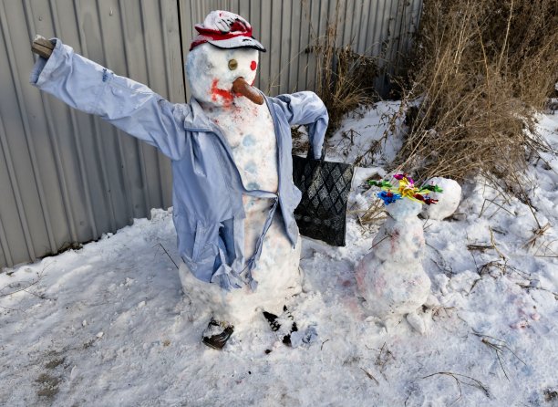 滑稽的雪人穿着一件旧外套和帽子图片下载