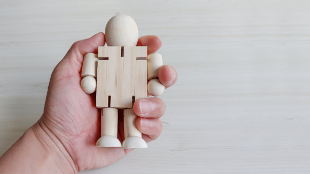 一只手拿着一个木娃娃图片下载