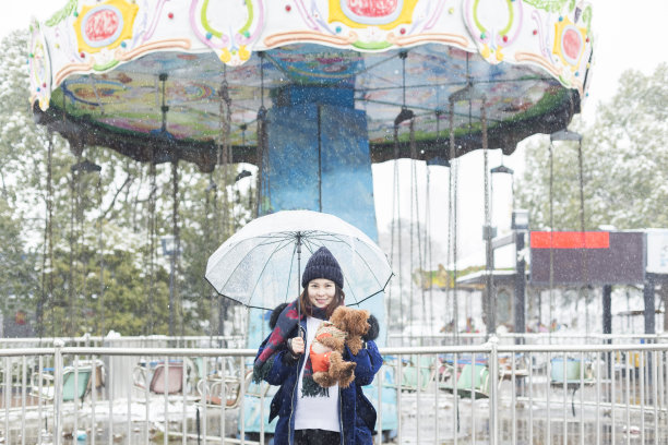 女人在旋转木马前拥抱她的宠物的肖像图片下载