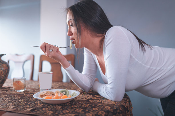 年轻孕妇在家吃沙拉图片下载