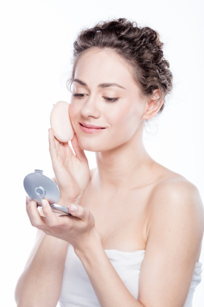 年轻，自然的女人在脸上搽粉。图片下载