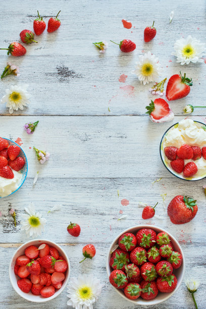 新鲜草莓和鲜奶油食品架装饰花在白色的桌子上。副本的空间。图片下载