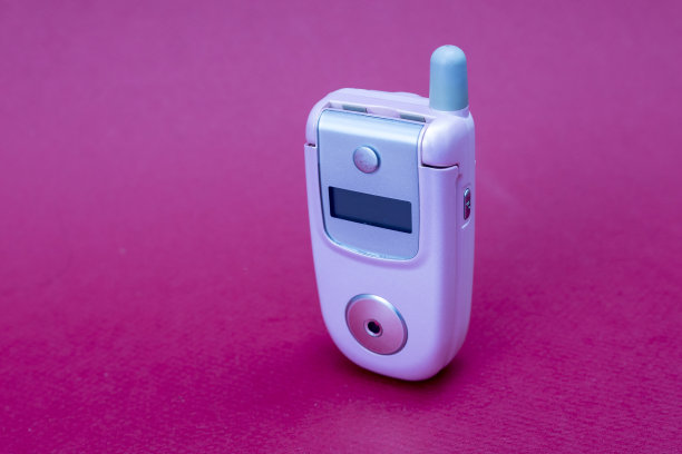 酷和经典的粉色复古翻盖手机或手机孤立的红色背景图片下载