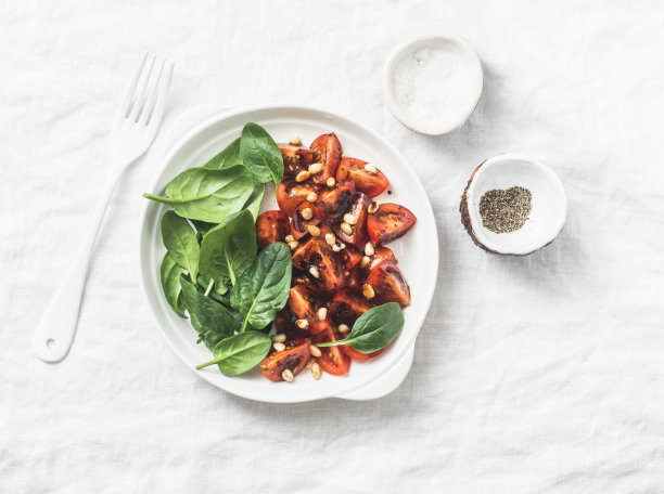 香醋樱桃番茄沙拉与松子，菠菜和烤面包在一个轻的背景，俯视图图片下载