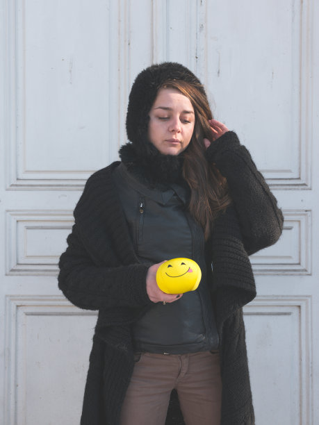 一个悲伤沮丧的女孩拿着黄色的笑脸表情符号的肖像照片图片下载