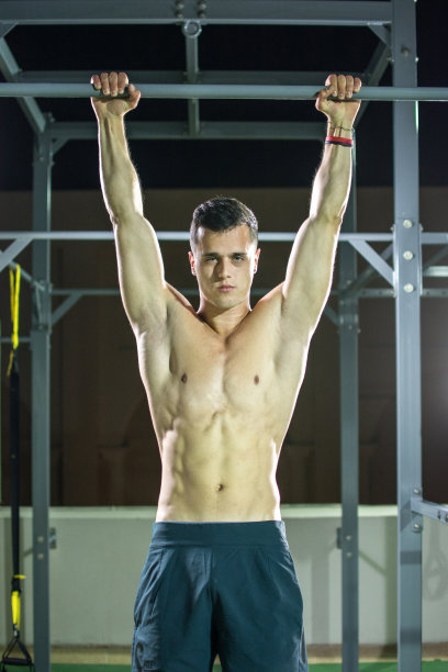 在户外健身房单杠上锻炼的年轻健壮赤膊男人图片下载