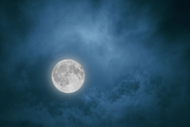 满月在夜空中透过云层照耀着图片下载