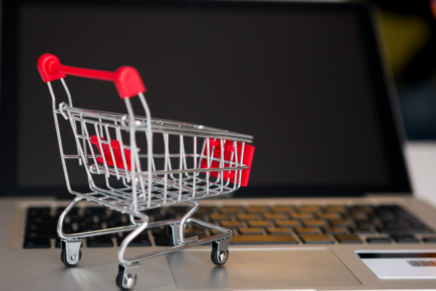 银行卡旁边放着笔记本电脑和迷你购物车图片下载