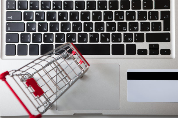 银行卡旁边放着笔记本电脑和迷你购物车图片下载