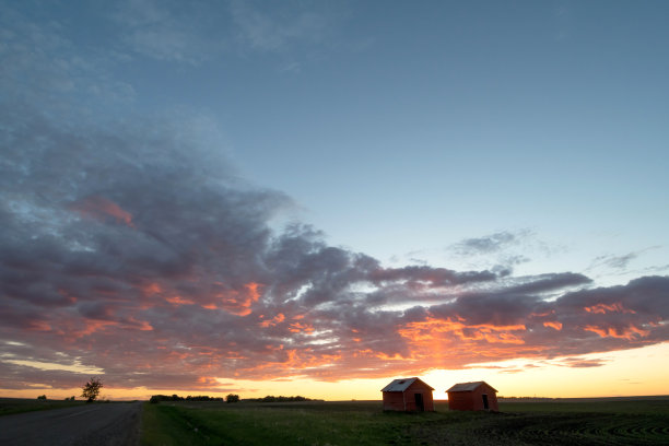 日落时分，阿尔伯塔省北部格兰德草原附近的农民田地里的红色谷仓图片下载
