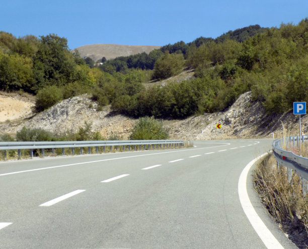 山区高速公路有危险的弯道和停车场路标图片下载