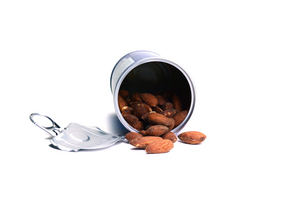 打开的烤咸杏仁在金属罐和盖子上的白色背景隔离图片下载
