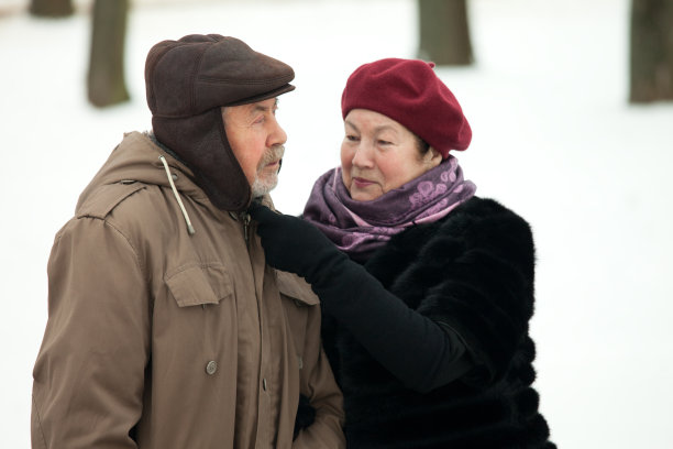 老年男女在冬季公园散步图片下载