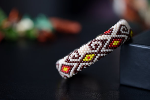 米色串珠手镯与东方图案在黑暗的背景近距离图片下载