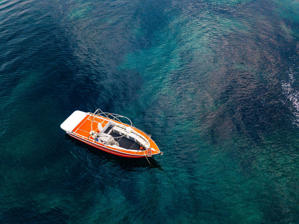 深蓝色海水里的红色小船。鸟瞰图图片下载