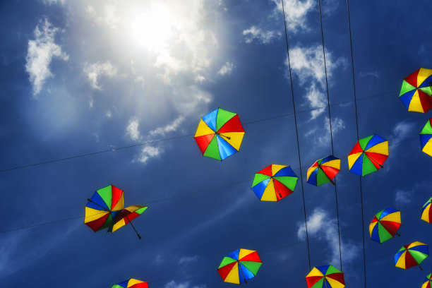 在深蓝色的天空下跳舞的彩色伞图片下载