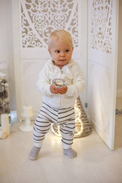 圣诞照片可爱的婴儿男孩在可爱的衣服摆姿势在装饰的房间图片下载