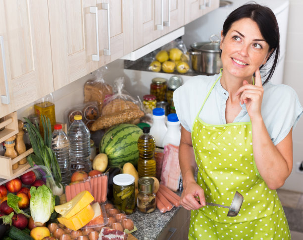 快乐的女人在厨房及时摆姿势做饭图片下载