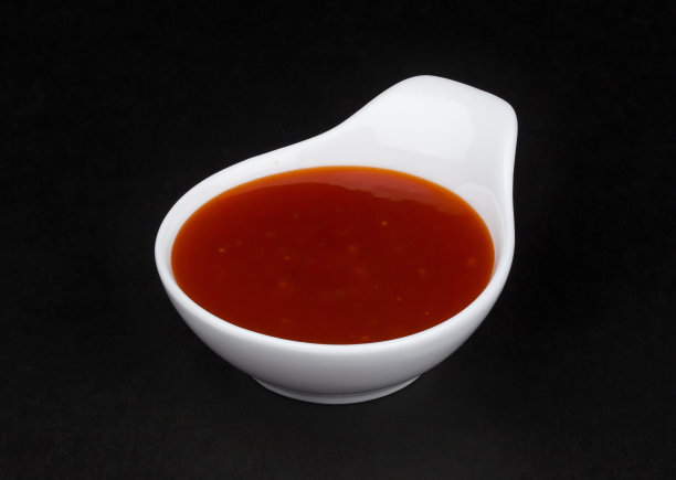 黑色背景的白色碗里的辣椒酱素材图片