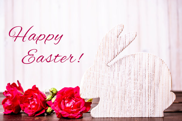 复活节快乐。特写的木制复活节兔子和玫瑰花在木制的背景。带有复制空间的模板。复活节概念和复活节贺卡。图片下载