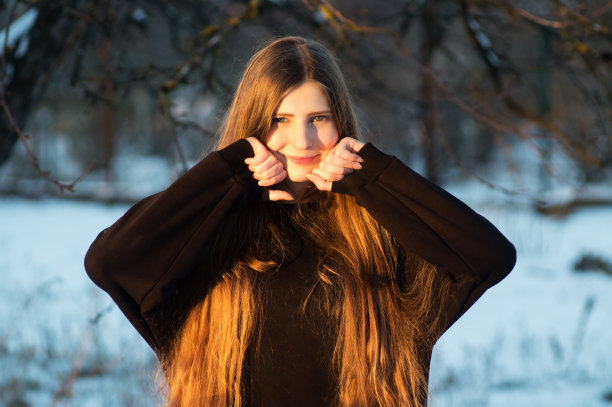 一个时尚模特在冬天的院子里穿着黑色的裙子拍照片图片下载