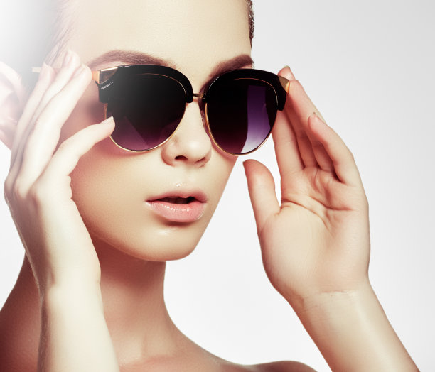时尚太阳镜。性感的女人在泳衣与金色的太阳镜和自然的化妆。魅力的照片，一个美丽的模特在白色比基尼和深色太阳镜图片下载