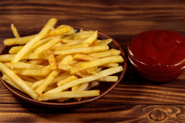 薯条和番茄酱放在木桌上图片下载