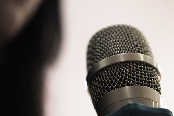 聪明的商业女性演讲和发言与麦克风在会议室或发言的会议厅灯光与麦克风和基调。语言是人类交流的发声形式。图片下载