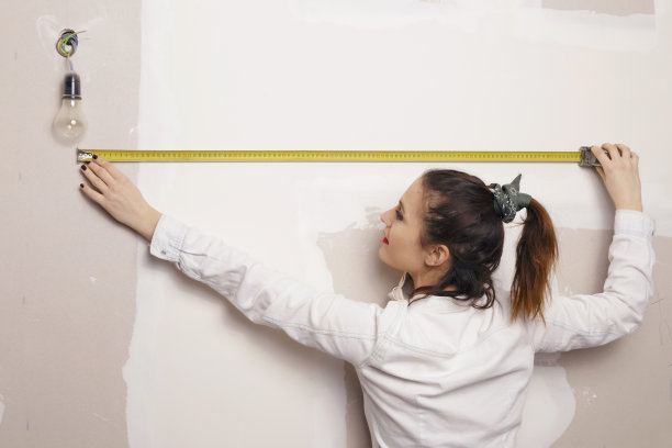 拿着卷尺在建筑工地工作的女人。图片下载