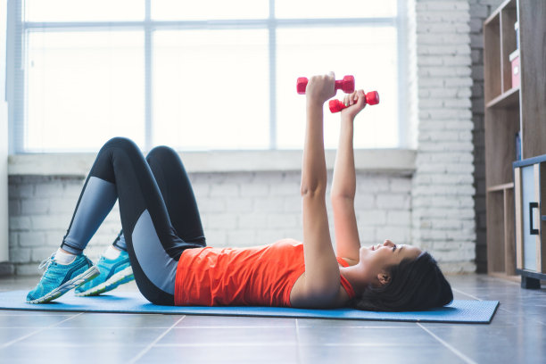 亚洲女孩，她习惯于坐直哑铃，减少上臂的震动。图片下载